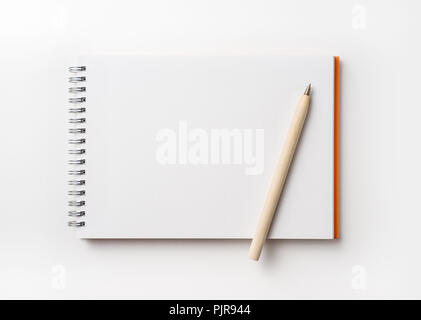 Design concept - Top view of orange spiral notebook and color pencil collection isolated on white background for mockup Stock Photo