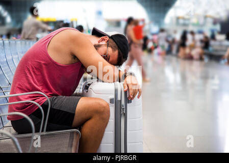 Man sleeping while waiting for transportation on the train station Stock Photo