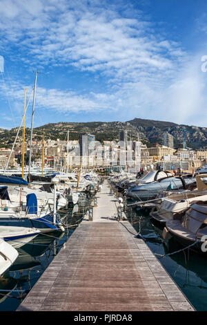 Yachts and sailing boats in Monaco principality, view from pier in Port Hercule to Monte Carlo at Mediterranean Sea Stock Photo