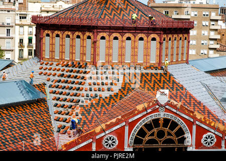 Men placing new tiles on a roof in Barcelona Stock Photo