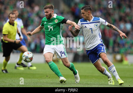 Northern Ireland's Stuart Dallas (left) and Bosnia and Herzegovina's Muhamed Besic battle for the ball during the UEFA Nations League, League B Group Three match at Windsor Park, Belfast. Stock Photo