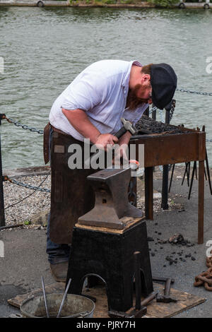 A blacksmith demonstrates how iron chains were forged for ships at the SS Great Britain exhibit in Bristol Stock Photo