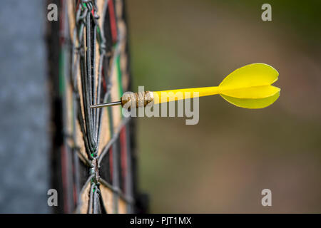 Yellow dart arrow hitting in the target of dartboard business success ideas concept Stock Photo