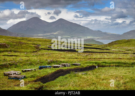 Trenches cut into deep Peat of wetland moors near Drinan on Isle of Skye Scotland with Loch Slap and Beinn Na Caillich mountain peak Stock Photo