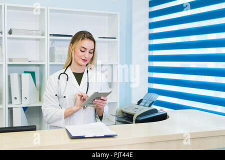 Female doctor using tablet at desk in office Stock Photo