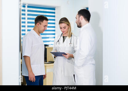 Doctors working in hospital and discussing over medical reports. Medical staff analyzing and working at clinic Stock Photo