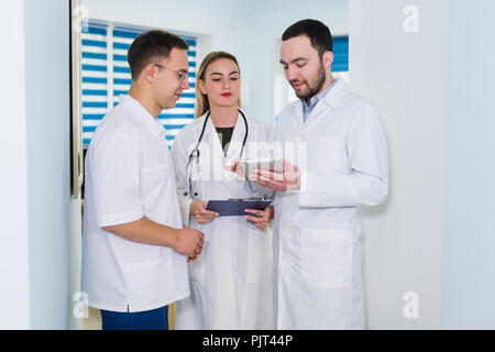 Doctors working in hospital and discussing over medical reports. Medical staff analyzing and working at clinic Stock Photo
