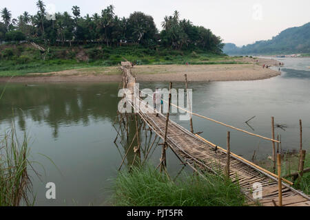 Female on a bamboo bridge over the Nam Khan River, Luang Prabang, Laos Stock Photo