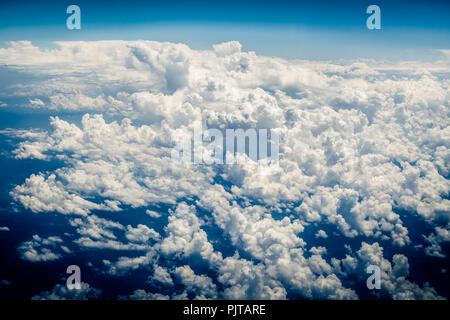 Dense white curly clouds on a blue background with a bird's eye view Stock Photo