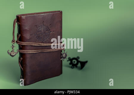 Handmade paper diary Notepad in brown leather case on green Christmas background. Stock Photo