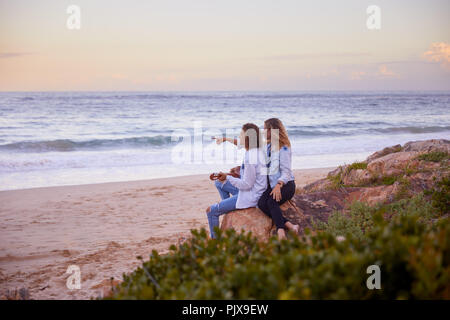 Couple relaxing on beach, Plettenberg Bay, Western Cape, South Africa Stock Photo