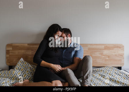 Man with hand on pregnant wife's belly Stock Photo