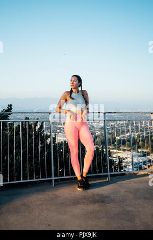 Woman leaning against railings on hilltop, Los Angeles, US Stock Photo
