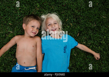 Children lying on grass Stock Photo
