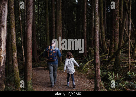 Father and daughter hiking in forest, Tofino, Canada Stock Photo