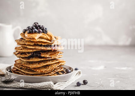 Stack vegan blueberry pancakes with peanut butter and syrup. Clean eating concept. Stock Photo