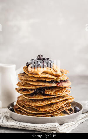 Stack vegan blueberry pancakes with peanut butter and syrup. Clean eating concept. Stock Photo