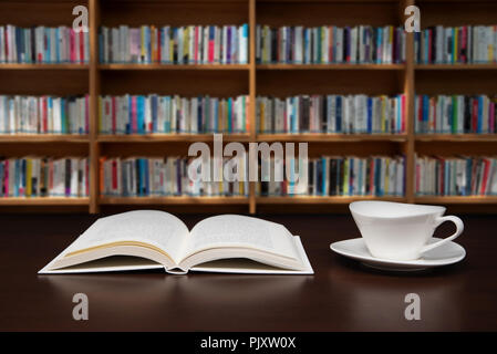 a book open on the desk with a cup of coffee. Stock Photo