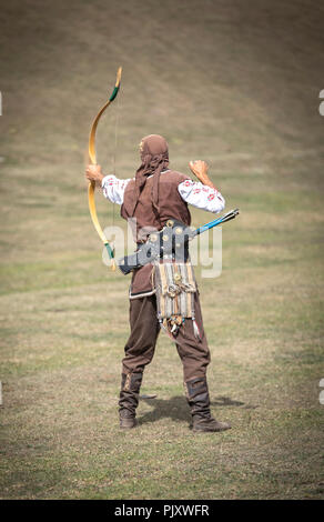 Lake Issyk-Kul, Kurgyzstan, 6th September 2018: young nomad shooting arrows in the nature Stock Photo