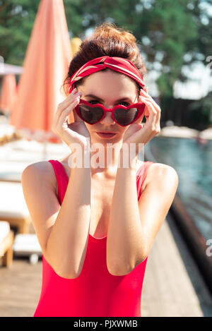 Nice young woman taking off her sunglasses Stock Photo