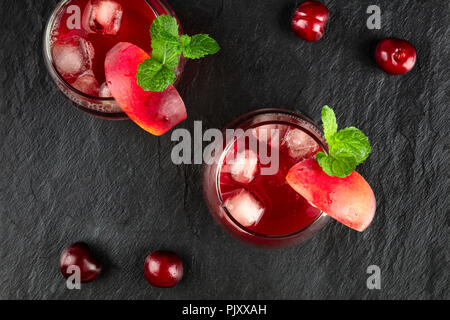 Overhead photo of vibrant red drinks with berries on black Stock Photo