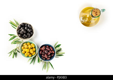 Overhead photo of various olives in bowls and a cruet of olive oil on white with copy space Stock Photo