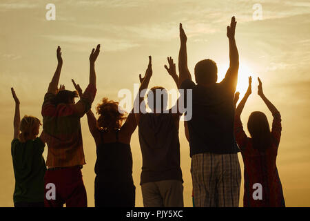 People raising hands up at the sky. Stock Photo