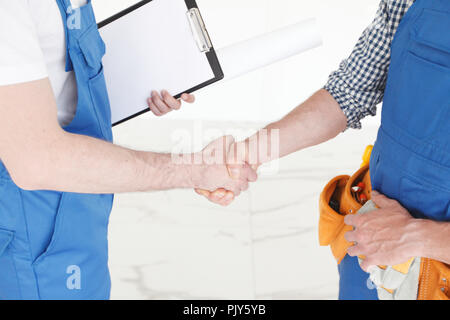 Two construction workers shaking hands, deal is finished concept Stock Photo