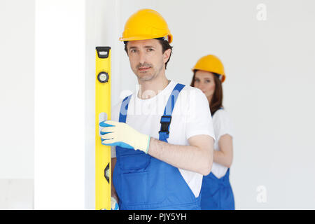 Team of workmen align wall using tools Stock Photo