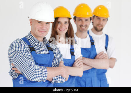 Group portrait of construction workers standing in a row and smiling Stock Photo