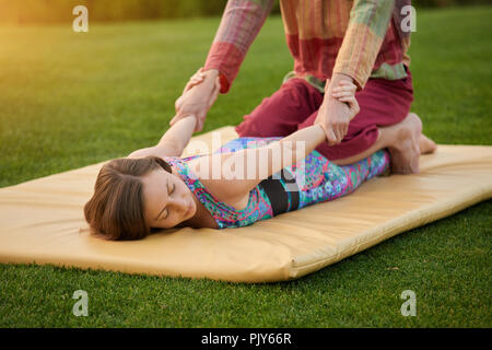 Young man and woman doing thai massage. Stock Photo