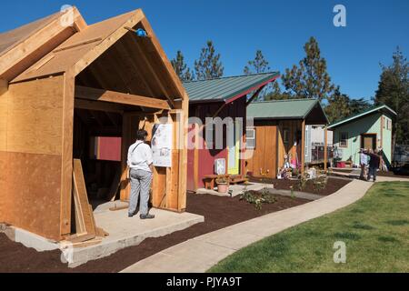 People touring houses in various states of completion at Emerald Village, a tiny house community in Eugene, Oregon, USA. Stock Photo