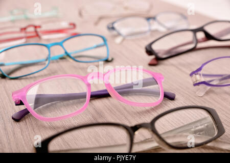 Stand of eyeglasses on wooden table in a eyewear store. Elevated view. Horizontal composition Stock Photo