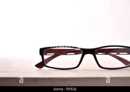Eyewear on wood table and white background front view detail. Front view. Horizontal composition Stock Photo