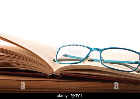 Reading glasses on wood table with open book. Concept need glasses to read. Front view. Horizontal composition