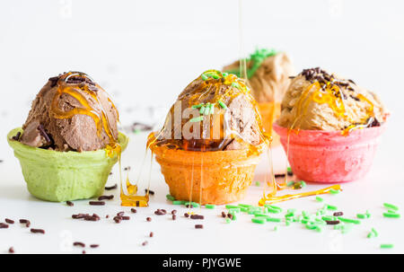 Small messy icecream cups  with sprinkles and syrup drizzled over on white background -  child birthday fun ice cream cones Stock Photo