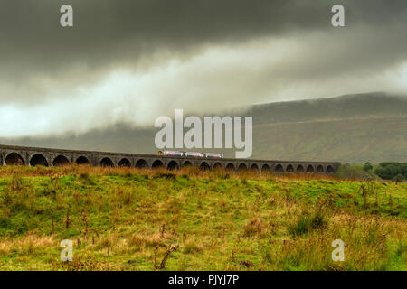 Yorkshire, UK. 9th September 2018: Drama in the storm clouds over Ribblehead Viaduct as Train crossing the dales, sheep hold up traffic along the B roads around the dales.  Clifford Norton Alamy Live News. Stock Photo