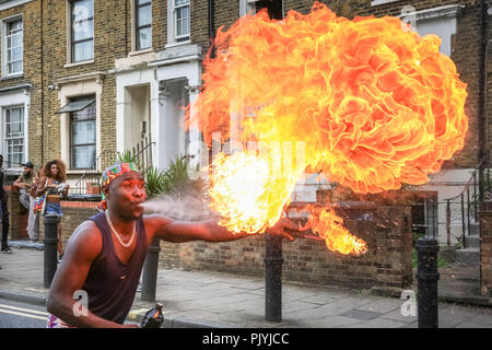 Hackney, London, 9th Sep 2018. A fire-eater, or fire spitter,  performing with GAHU Dramatic Arts.The annual Hackney Carnival sees over 1,000 performers, dancers and musicians participate in the festivities in the North London suburb. The carnival, originally with Afro-Caribbean roots, includes many local communities but also attracts revellers and performers from a variety of other cultural backgrounds. Credit: Imageplotter News and Sports/Alamy Live News Stock Photo