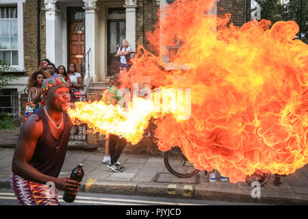 Hackney, London, 9th Sep 2018. A fire-eater, or fire spitter,  performing with GAHU Dramatic Arts.The annual Hackney Carnival sees over 1,000 performers, dancers and musicians participate in the festivities in the North London suburb. The carnival, originally with Afro-Caribbean roots, includes many local communities but also attracts revellers and performers from a variety of other cultural backgrounds. Credit: Imageplotter News and Sports/Alamy Live News Stock Photo