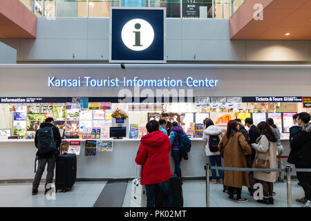 Japan, Osaka. Kansai International Airport. KIX, Interior terminal one, ground floor tourist information desk with people waiting. Stock Photo