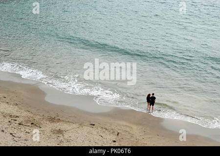 Young couple standing on the beach, looking out to sea, at St Davids Peninsula Stock Photo
