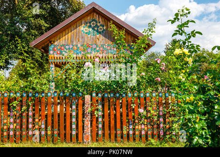 Zalipie, Poland, August 19, 2018:  Colourful house with flowers painted on walls and sundial in the village of Zalipie, Poland. It is known for a loca Stock Photo