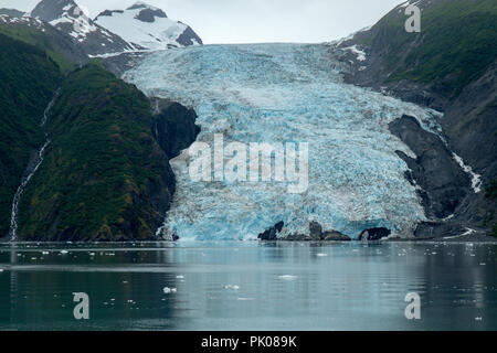 College Glacier in Prince William Sound, Alaska, USA. Blue ice can be seen on glacier, calm water in the foreground. Stock Photo