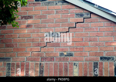 Brick and mortar separation on a red brick wall.This is typically due to a sinking foundation in a structure. Stock Photo