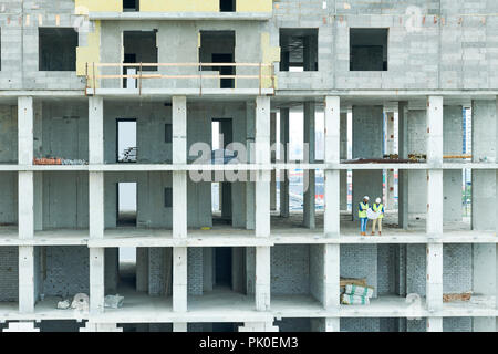 Building workers analyzing project plan Stock Photo