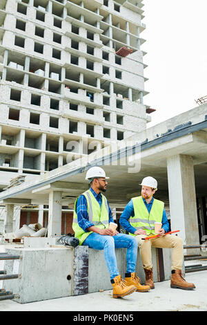 Multiethnic engineers having break at construction site Stock Photo