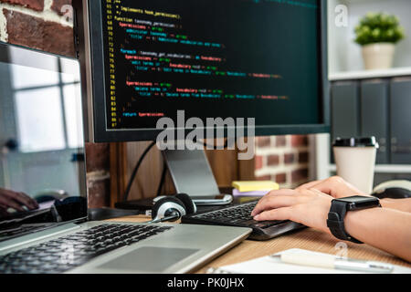 the closeup view of typing codes on computer by female programmer's hand. Stock Photo