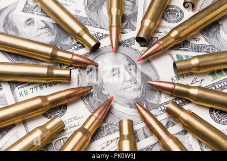 concept of live ammunition is aimed at a portrait of Benjamin Franklin on a hundred dollar bill. The symbol of war and danger Stock Photo