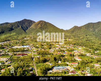 Aerial view of the edge of Ruteng with dramatic mountains in the background in East Nusa Tenggara, Indonesia. Stock Photo