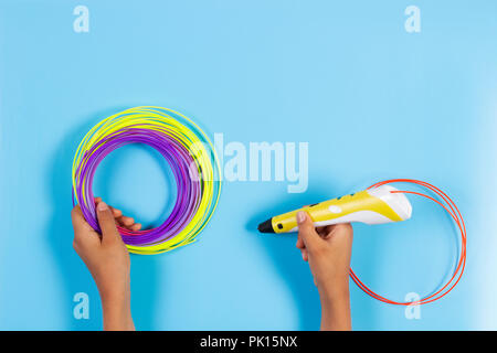 Child draws with 3d pen. Kid holding 3d pen with plastic filament Stock Photo